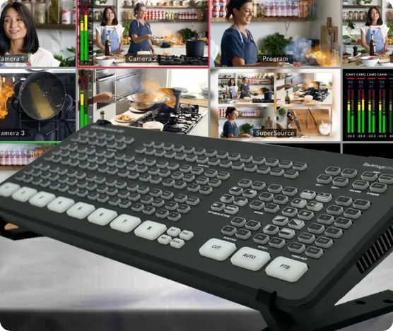 Spruce Tree Media A video production switcher is in the foreground, seamlessly integrating with a live streaming setup. Behind it, a screen displays multiple views of a cooking show, capturing chefs preparing dishes in the kitchen. Various controls and monitoring bars enhance this dynamic streaming experience. Web Design Videography, Photography Web Development